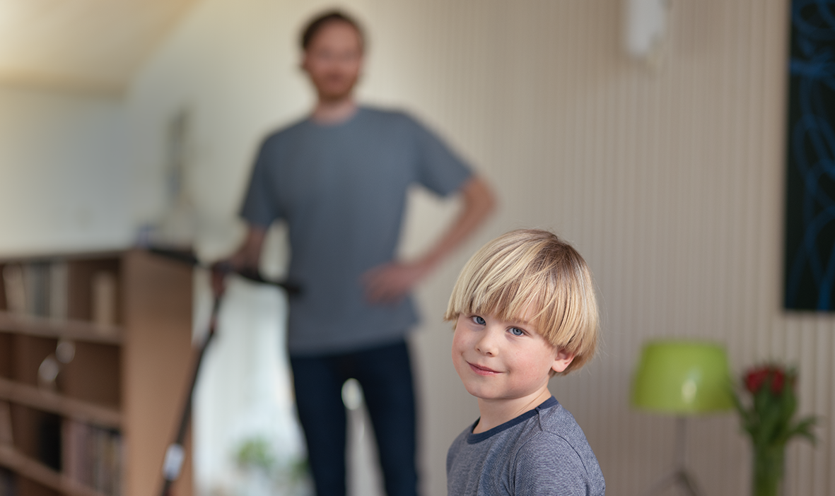 Gutt med pappa og elsparkesykkel i bakgrunnen.